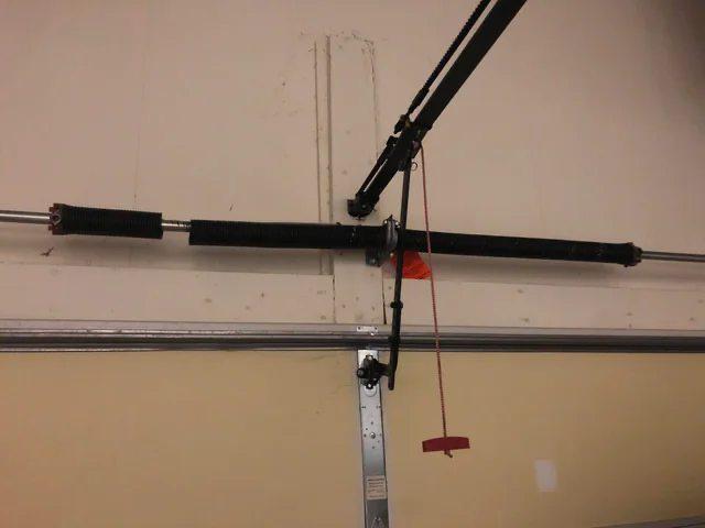 Garage door torsion spring system above a residential garage door